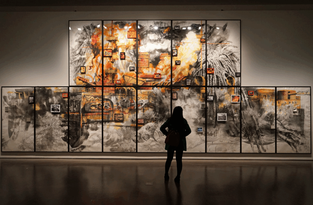 Ein Mensch steht vor einem Kunstwerk in einem Museum
